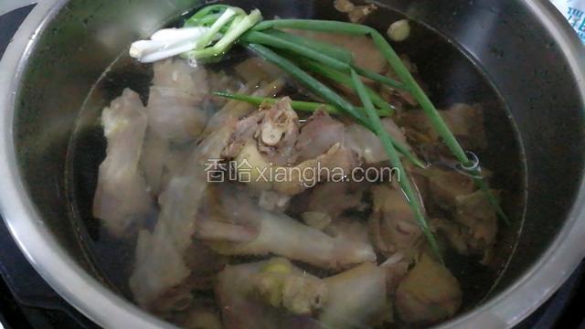 捞出鸭肉放入电压力锅里，加水和葱姜，少许醋。