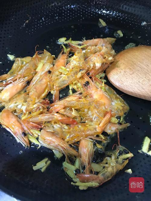用铲子稍用力压虾头,炒至有虾色油出来