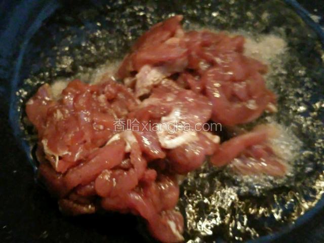 锅里倒油加热，放入腌制好的肉丝。