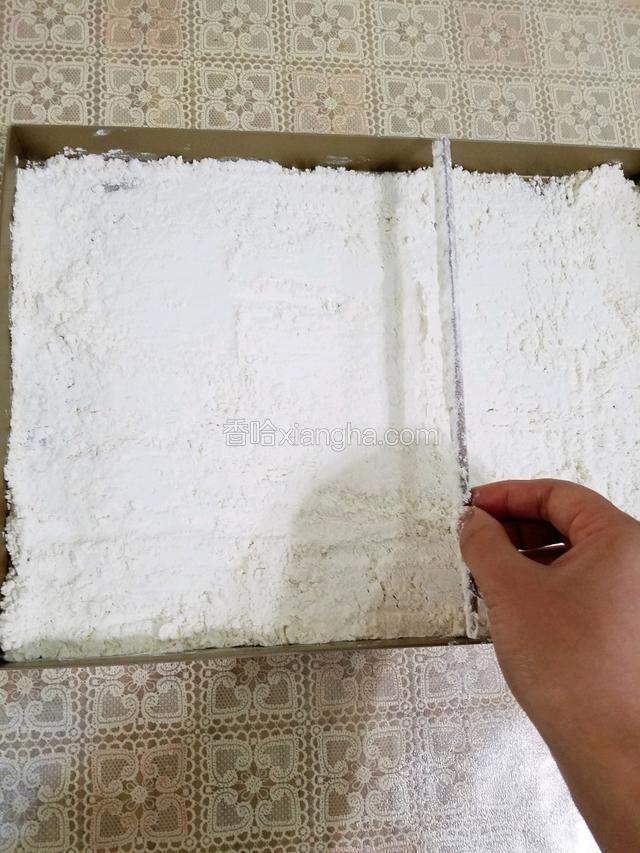 低筋面粉用筷子抹平铺在烤盘上，放入烤箱中层，150度上下火烘烤10分钟。