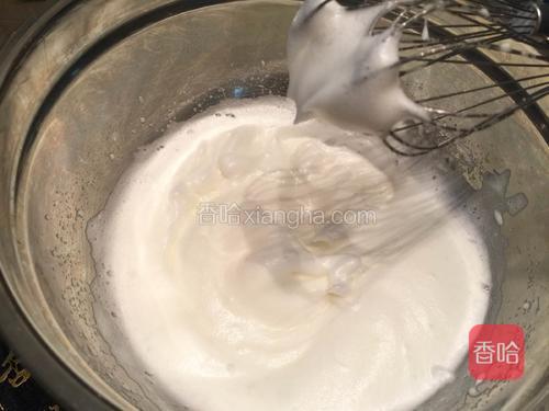 接着打至蛋白泡沫变细，且提起打蛋头，蛋白霜会挂着时，再加入1/3细砂糖；