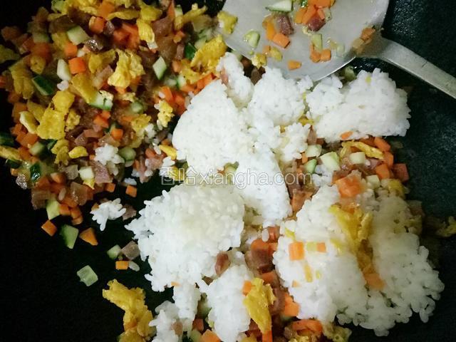 倒入剩米饭，用铲子切的手法把米饭打散开