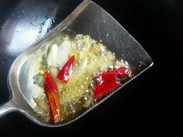 备好小料，热锅起油，高温时铲一铲油，如图爆香小料。