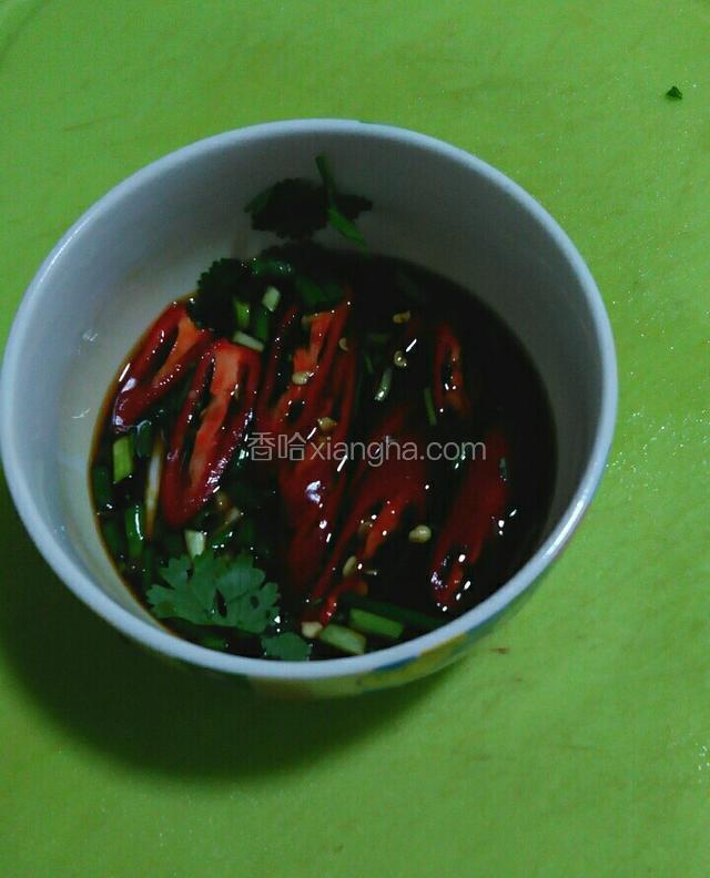 蒸鱼的过程中我们来先调配一下这个料汁。取一个小碗，放入豆鼓酱油。红辣椒。香菜，料酒，小葱花，姜丝。白糖，温水。
