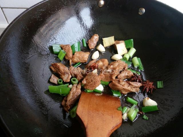 锅中油热后，加葱姜蒜炒香，下入排骨煸炒。