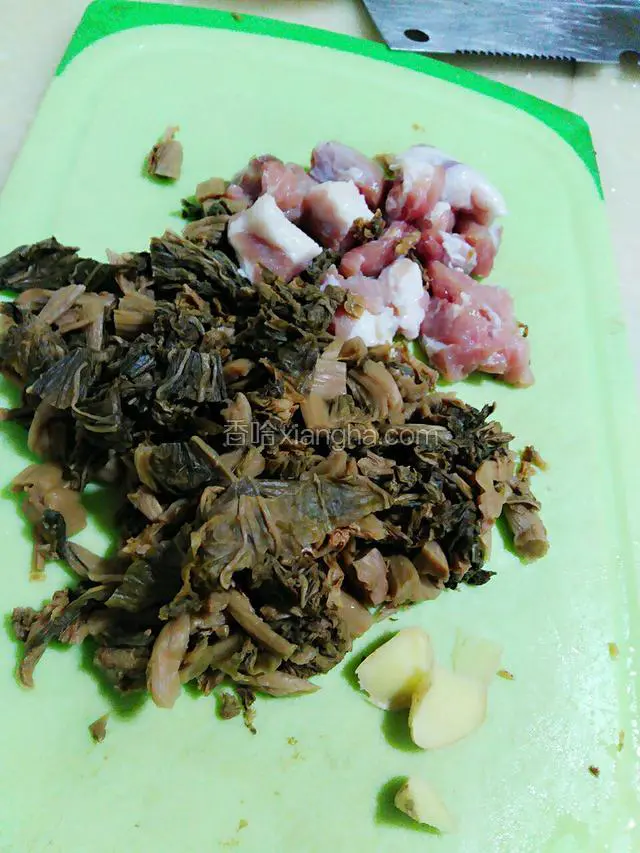 将猪肉和梅菜切一下。