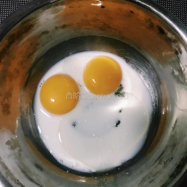 先制作蛋黄糊：酱玉米油和牛奶倒进蛋黄里，用手动打蛋器将其搅拌至乳化。