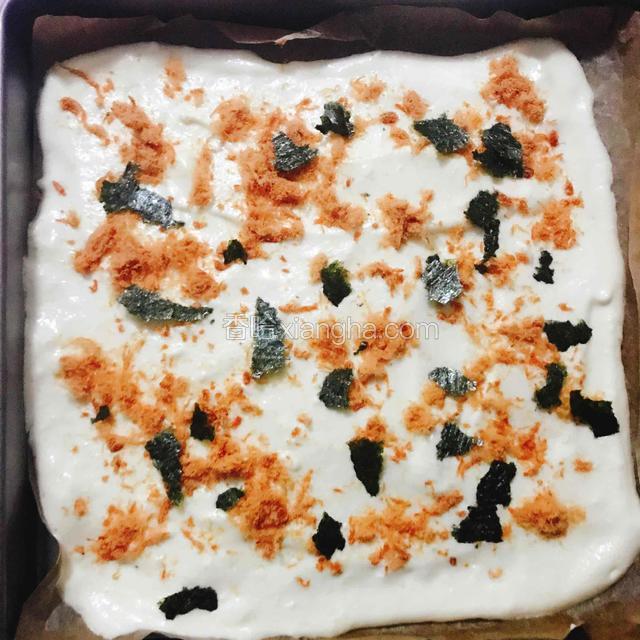 烤盘放入油纸，将制作好的蛋糕糊倒进油纸中，用刮刀抹平表面，然后均匀的撒上牛肉松和海苔碎。