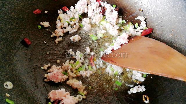 用木铲把肉末炒散开。