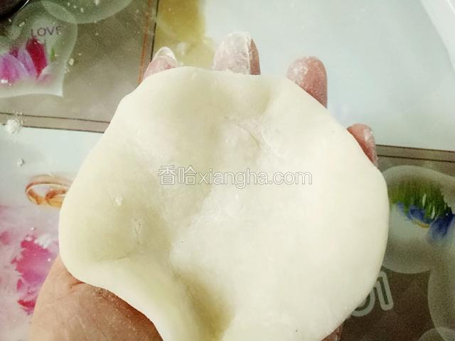 用手指手掌捏成中间厚边缘薄的圆形面片