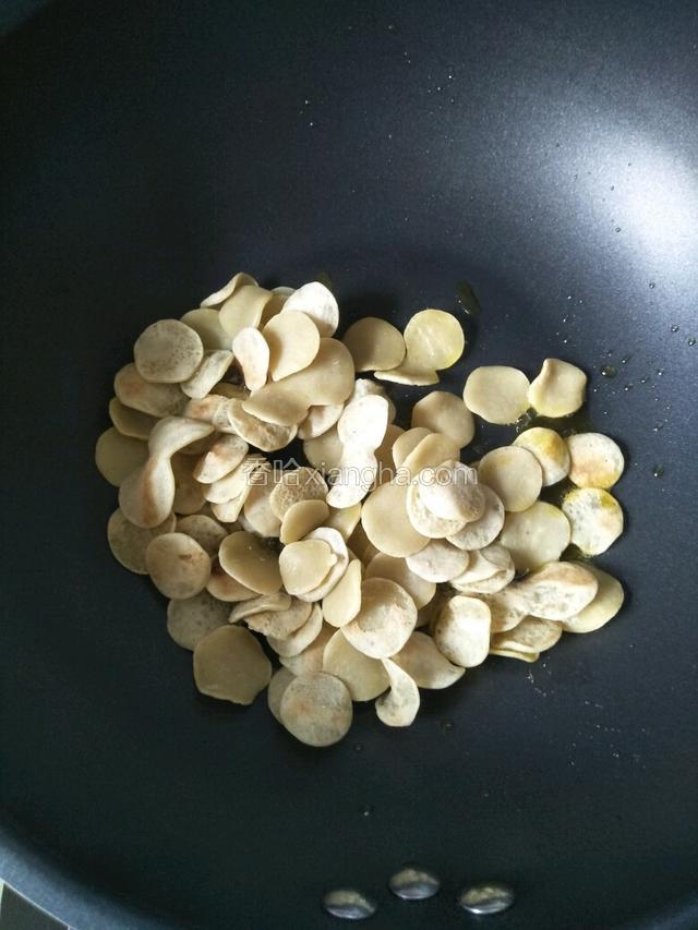 锅中倒油烧热，倒入豆饼翻炒