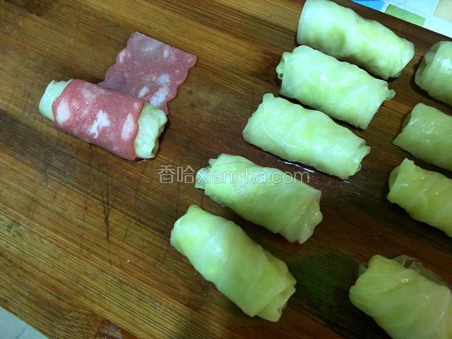 取半片培根将包菜卷再卷起来