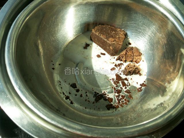 盆里放入黑巧克力和少许牛奶 隔水加热 放牛奶是担心淋面的时候巧克力太硬 冷却后会裂开