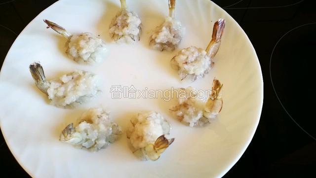 把做好的虾泥分八份，依次放到摆好的虾仁上。凤鸟的身体和窝就做好了。