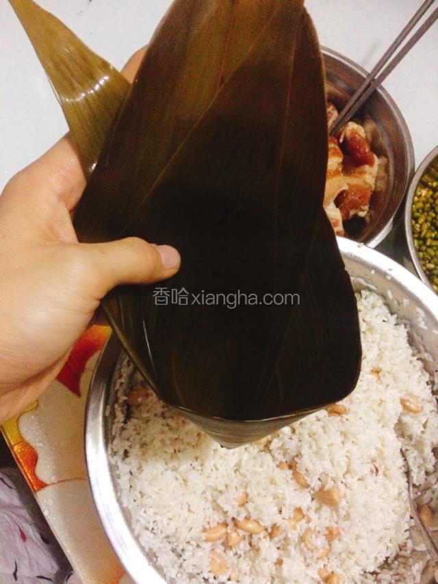 把粽叶卷成一个圆锥形，注意底部要卷实不要露出小洞。