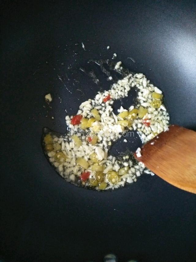 倒入蒜末和泡椒炒香