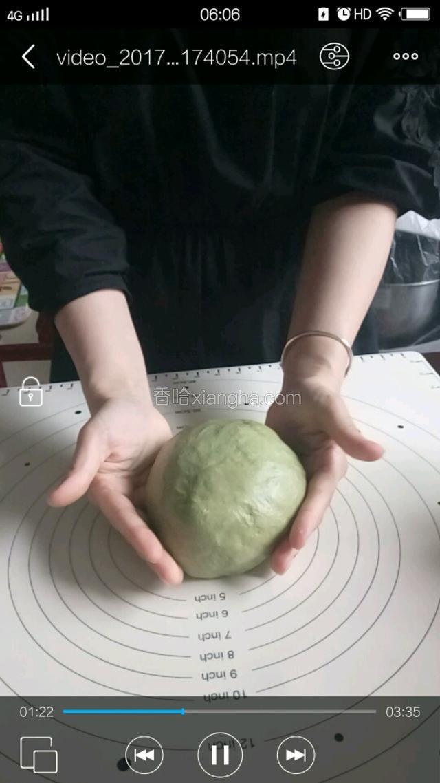 然后将发酵好的面团移到揉面垫上，用手按压排气整形成圆形。