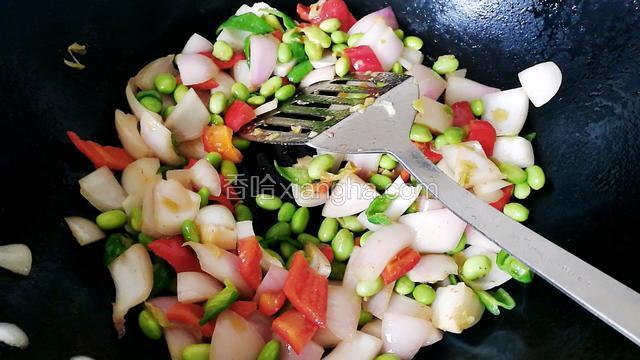 锅中倒油，倒入洋葱，青红椒片，毛豆米煸炒断生。
