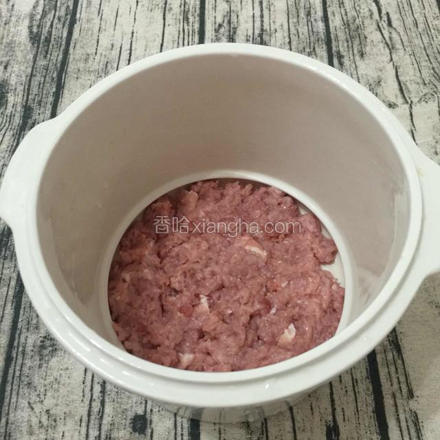把搅碎的肉平铺在炖锅底