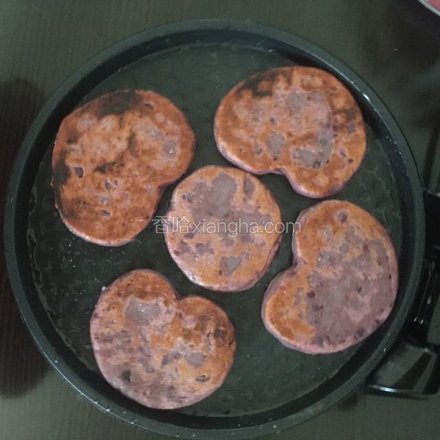 用爱心磨具做饼，用电饼档加热三分钟开始烙饼，锅低放少许油，大约7分钟饼熟出锅