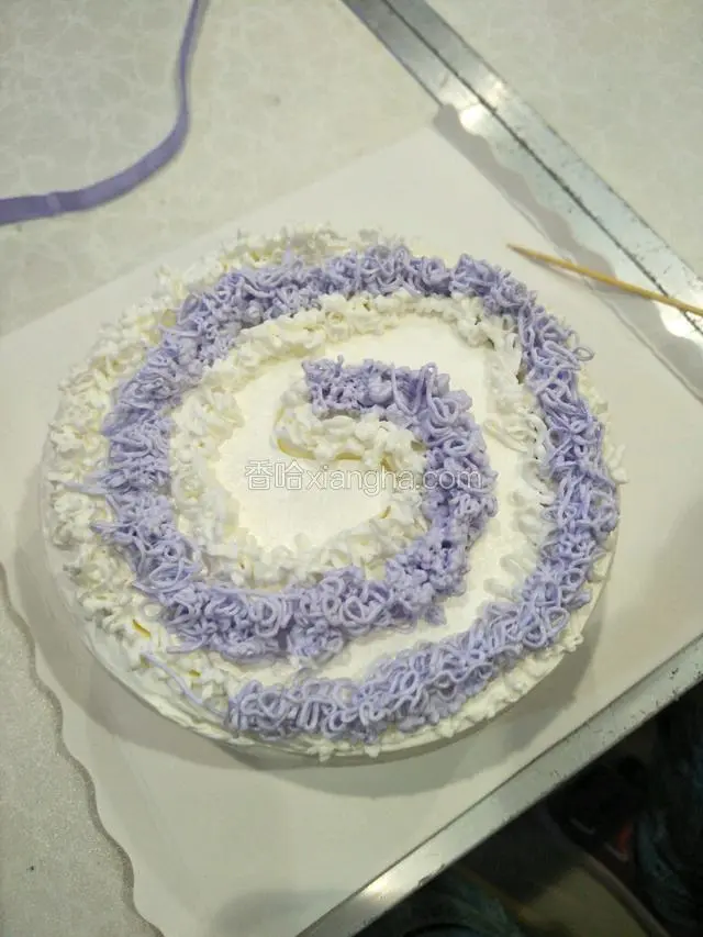 用紫色奶油按照画好的形状挤出奶油，再用白色奶油把控的地方挤出白色奶油