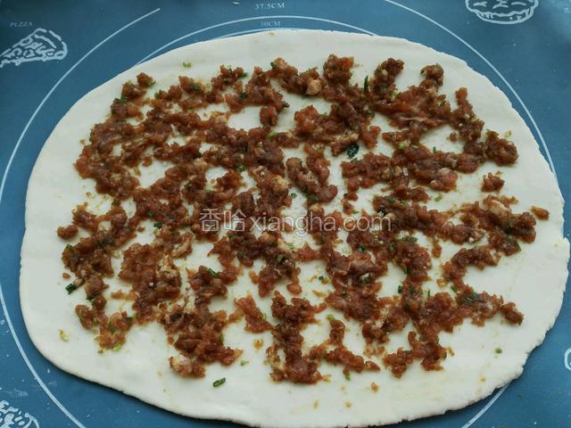 把调好的肉馅均匀的撒在饼皮上