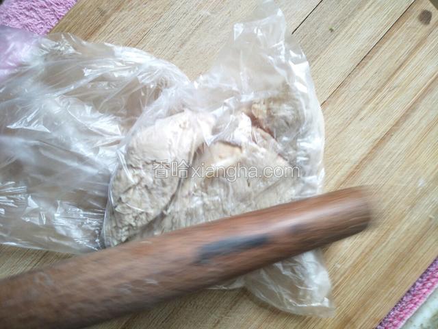 用擀面杖敲打鸡肉