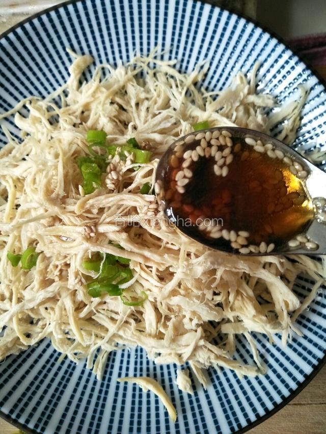 葱叶撒在鸡丝上，把调好的汁浇在鸡丝上