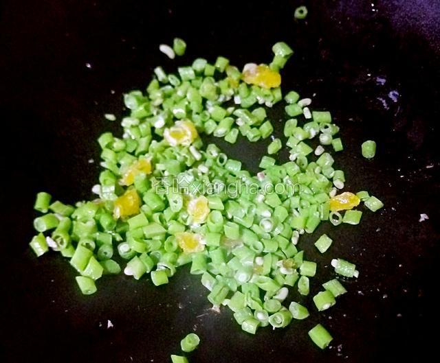 然后倒入咸鸭蛋黄用铲子切碎翻炒五六分钟