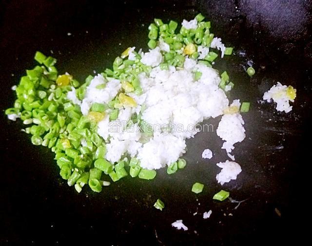 将米饭和豆角粒翻炒至均匀