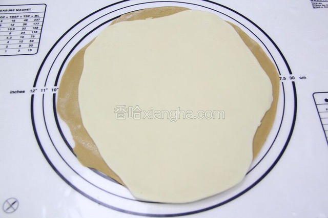 把2块面团用擀面仗，擀成面饼重叠起来。