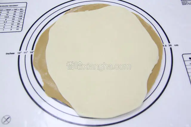 把2块面团用擀面仗，擀成面饼重叠起来。