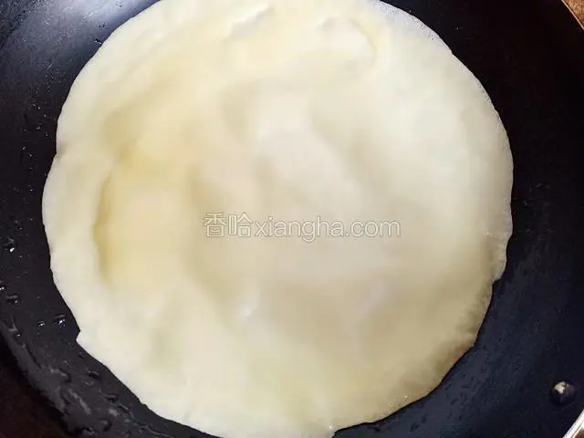 准备不粘平底锅，用小火煎烙，舀一勺面糊倒入锅中，适当晃动锅子，摊成一个圆形薄饼，待面糊凝固定型，饼边微微翘起就可以倒出，平整的放在盘子里晾凉备用(不要翻面，只煎一面)