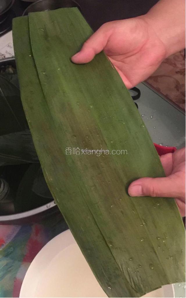 取两个棕叶叠放在一起，两头剪去尖头。