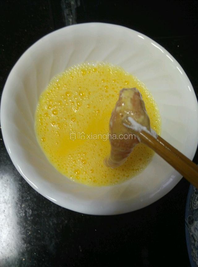 把沾过面粉的鸡柳滚一层蛋液。