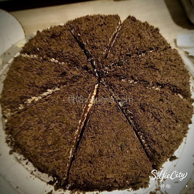 中间加打好的奶油，还有自己喜欢的水果。一层面包胚子，一层奶油水果。直至铺完。再在最上面铺巧克力碎。一个黑森林蛋糕就完成啦。这个得忘记牌照了，这是切了的。看起来有木有食欲。哈哈哈