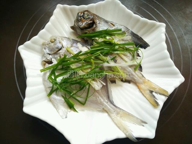 鱼的表面铺上葱丝。