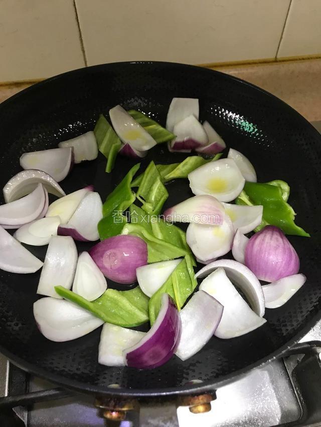 锅内放入适量油、7成热下洋葱、青椒颠锅炒熟