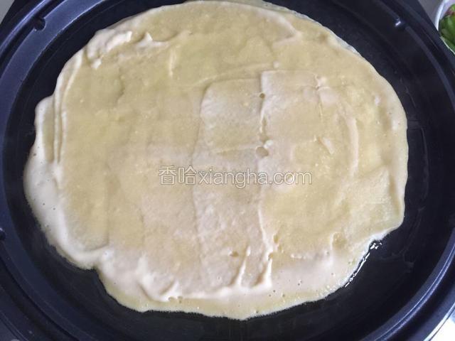 电饼铛预热后，倒入适量面糊，均匀的铺满锅底，可以用刮刀帮助一下，尽量薄一些。