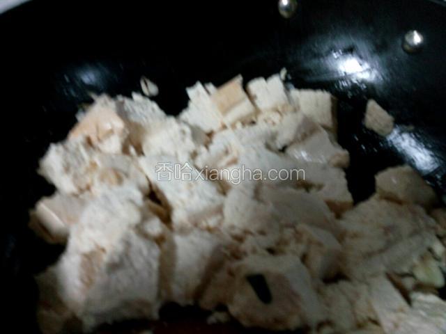 加豆腐翻炒，用铲子把豆腐切碎。