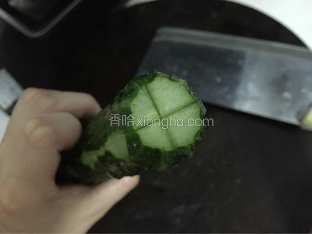 用刀在青瓜尾部划个“十字”。