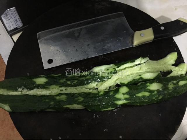 青瓜平放在砧板上，用刀将它拍扁、拍碎。