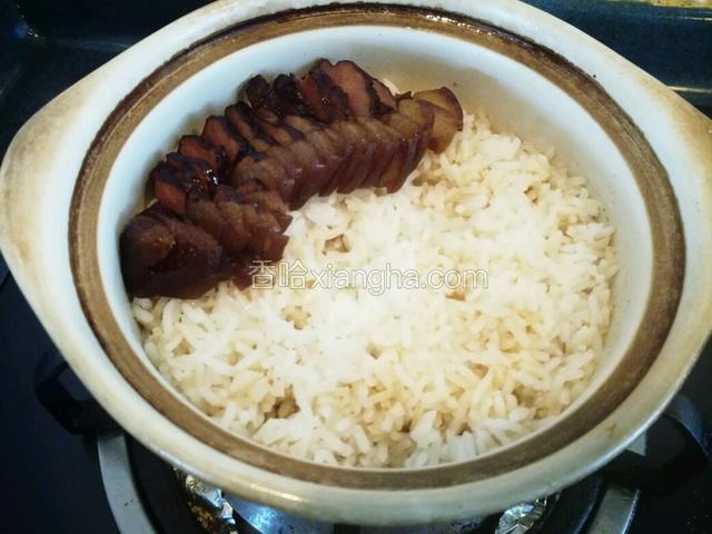 铺上煮熟的腊肉。