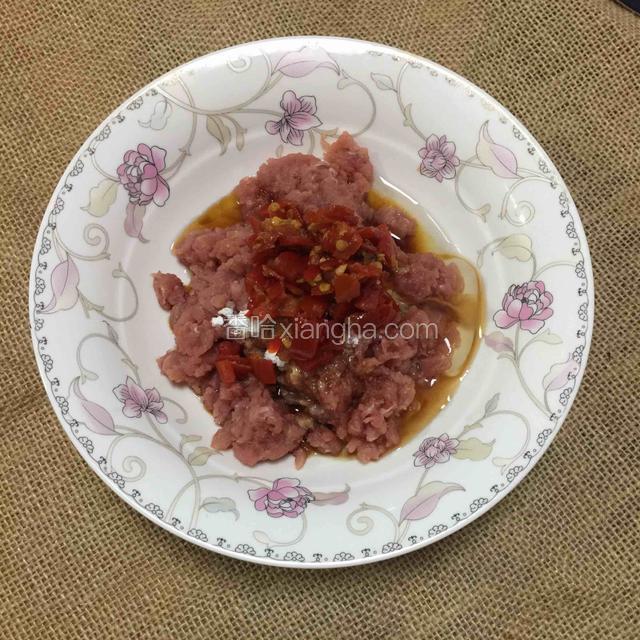 鸡蛋取蛋清倒入肉糜，加入蒸鱼豉油，剁椒，生粉搅拌均匀