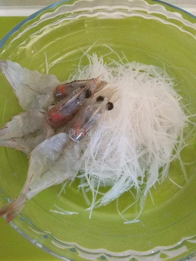 泡好的粉丝放在盘子里,把开背的虾放在粉丝上边。