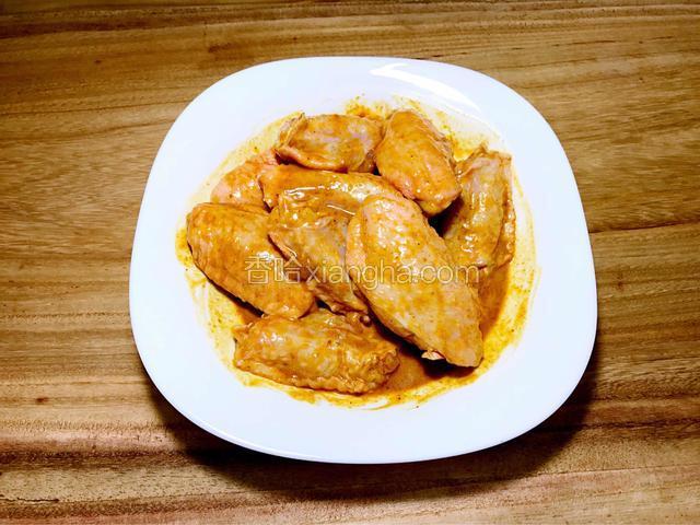 鸡翅解冻清洗后，用1匙咖喱酱、生粉、糖、豉油、胡椒粉拌匀腌2小时