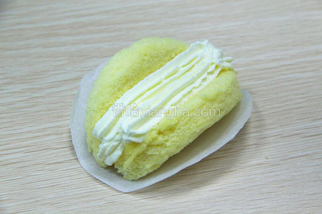 取一蛋糕片稍微对折，挤上奶油