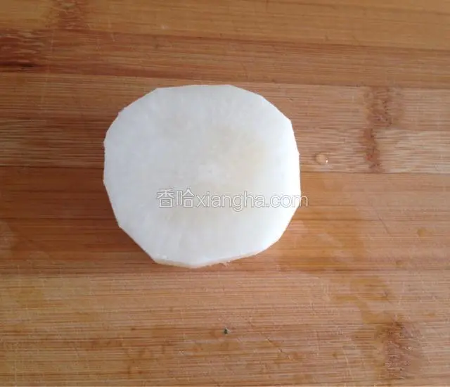 取出一块萝卜，用削皮刀削去外皮