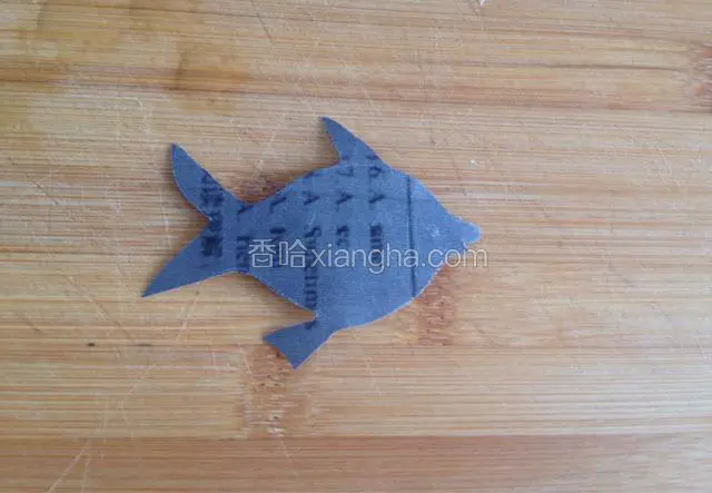 取纸一张，用剪刀剪出鱼的形状