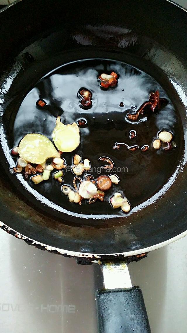 热锅里放油，下姜、八角、桂皮、葱白部分爆出香味